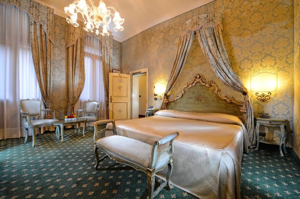 a bedroom with a bed and a chandelier at Cà Rialto in Venice