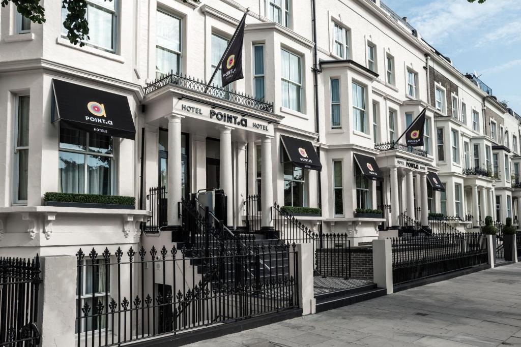 a row of white buildings with flags on them at Point A Kensington Olympia in London