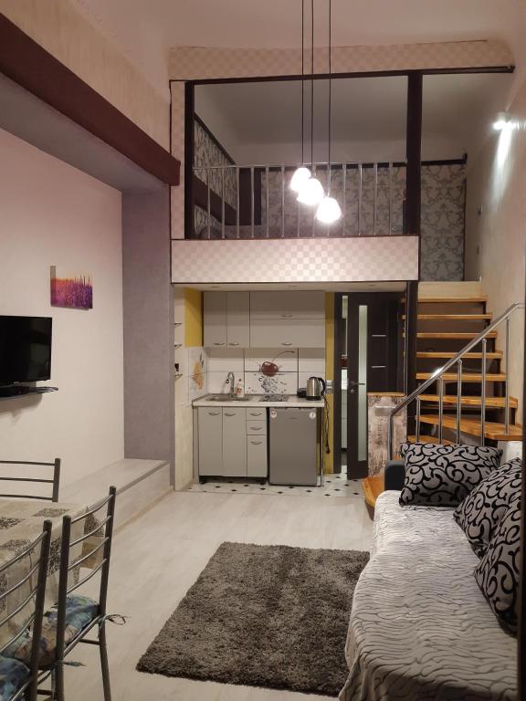 ein Wohnzimmer mit einem Sofa und einer Küche in der Unterkunft Квартира студія подобово 3 in Lwiw