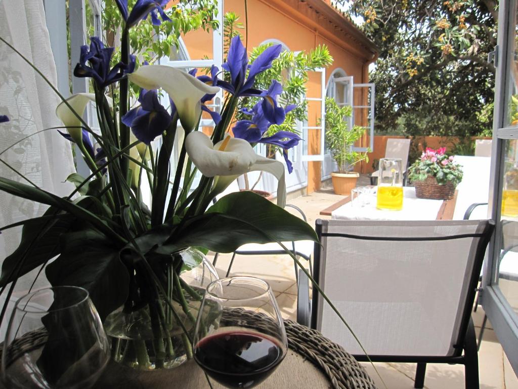 een tafel met een vaas met bloemen en een glas wijn bij Casa rural el Gargujo in Santa Brígida