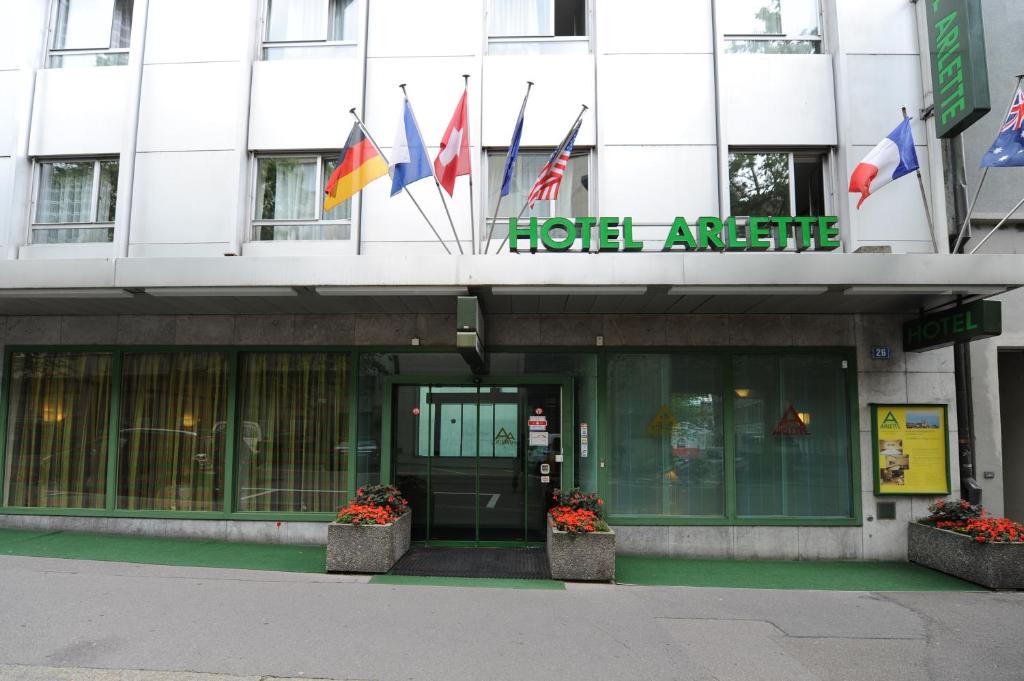 una fachada de un edificio con banderas. en Hotel Arlette Beim Hauptbahnhof, en Zúrich