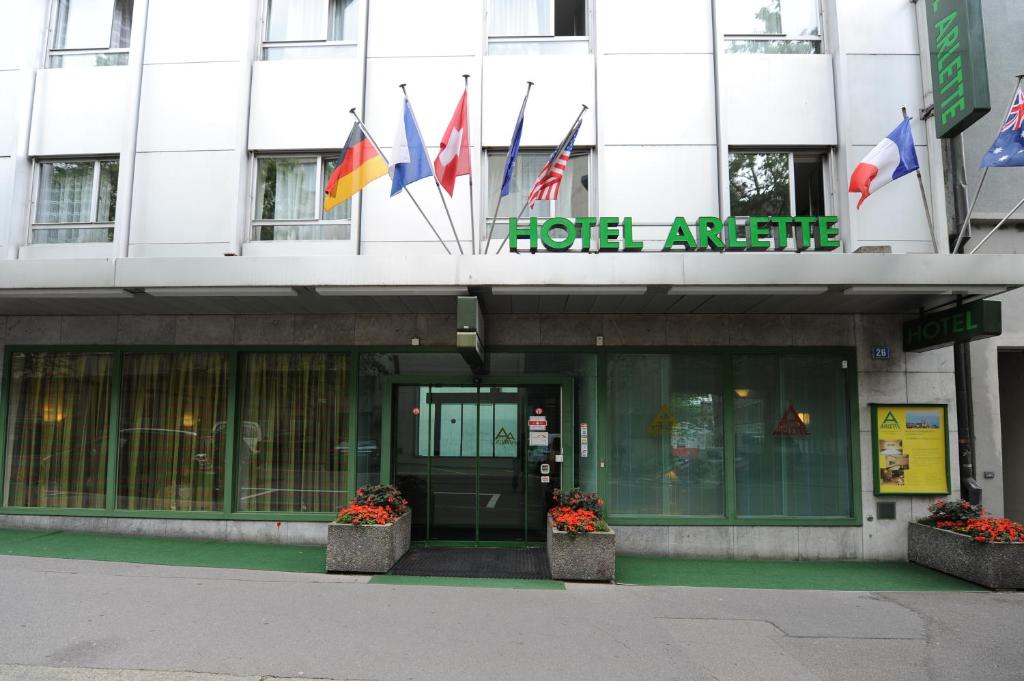 uma fachada de um edifício com bandeiras em Hotel Arlette Beim Hauptbahnhof em Zürich