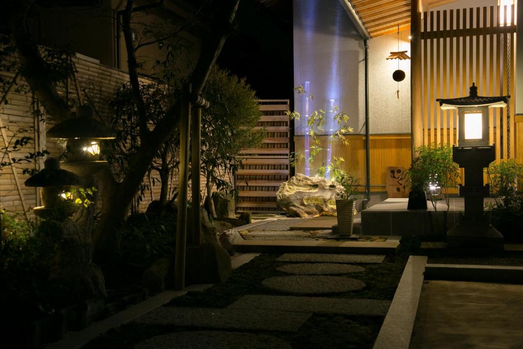 - une cour avec un banc et une fontaine la nuit dans l'établissement Waso Mukuge, à Sakaiminato
