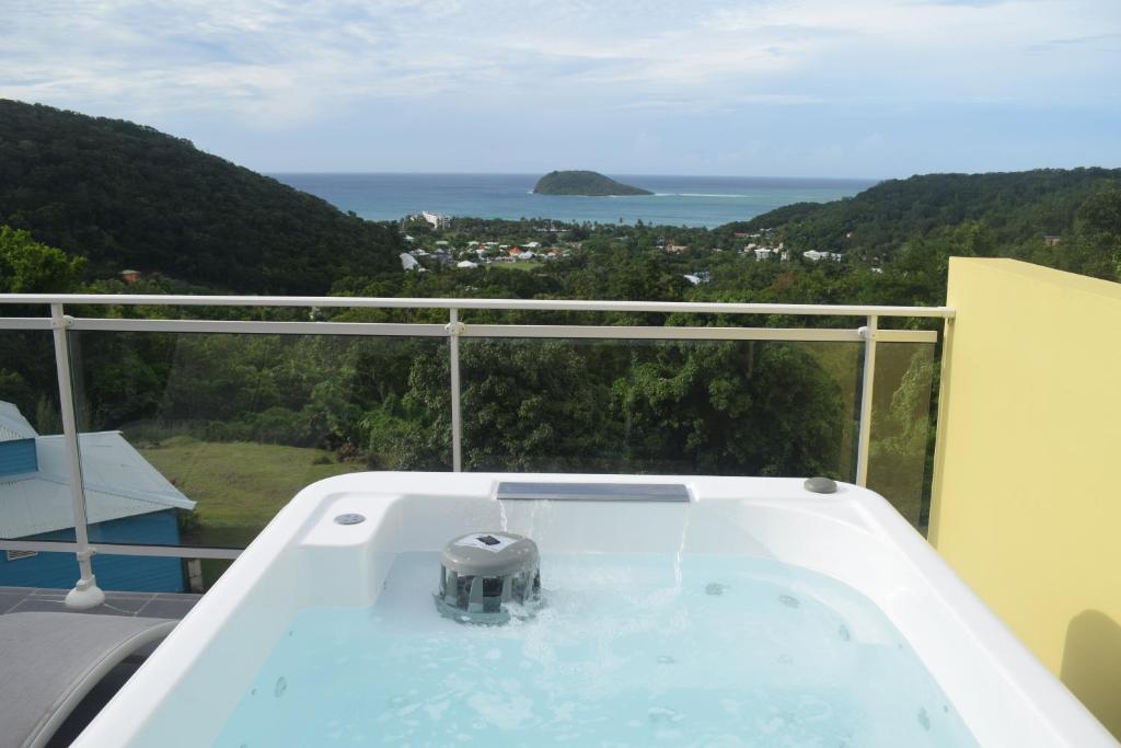 a bath tub with a view of the ocean at Habitation Pineau in Deshaies