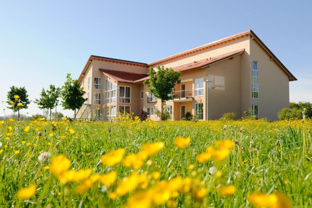 une maison dans un champ de fleurs dans l'établissement Hotel Inspiration Garni, à Tittmoning