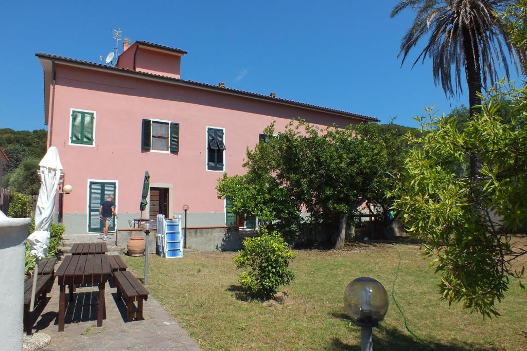 a pink house with a picnic table in front of it at Casale Al Mare in Marina di Campo