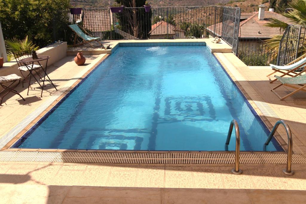 a large swimming pool with blue water in a backyard at Jerusalem Mansion in Jerusalem