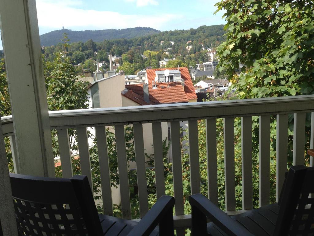 a balcony with chairs and a view of a town at Petite Bellevue in Baden-Baden