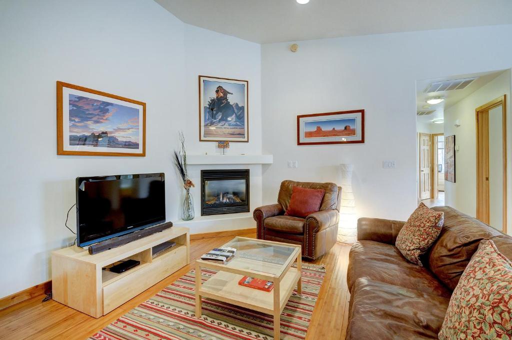 a living room with a couch and a flat screen tv at Cottonwoods 405 in Moab