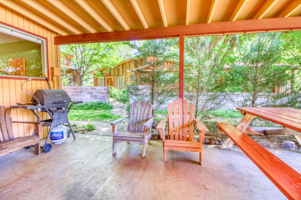 a screened in porch with two chairs and a grill at Creekside Juanita's Place in Moab