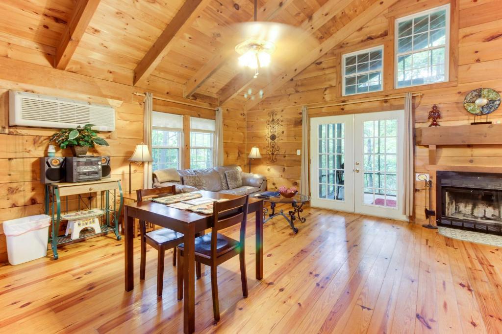 a living room with a table and a fireplace at Country Cottage in Sautee Nacoochee