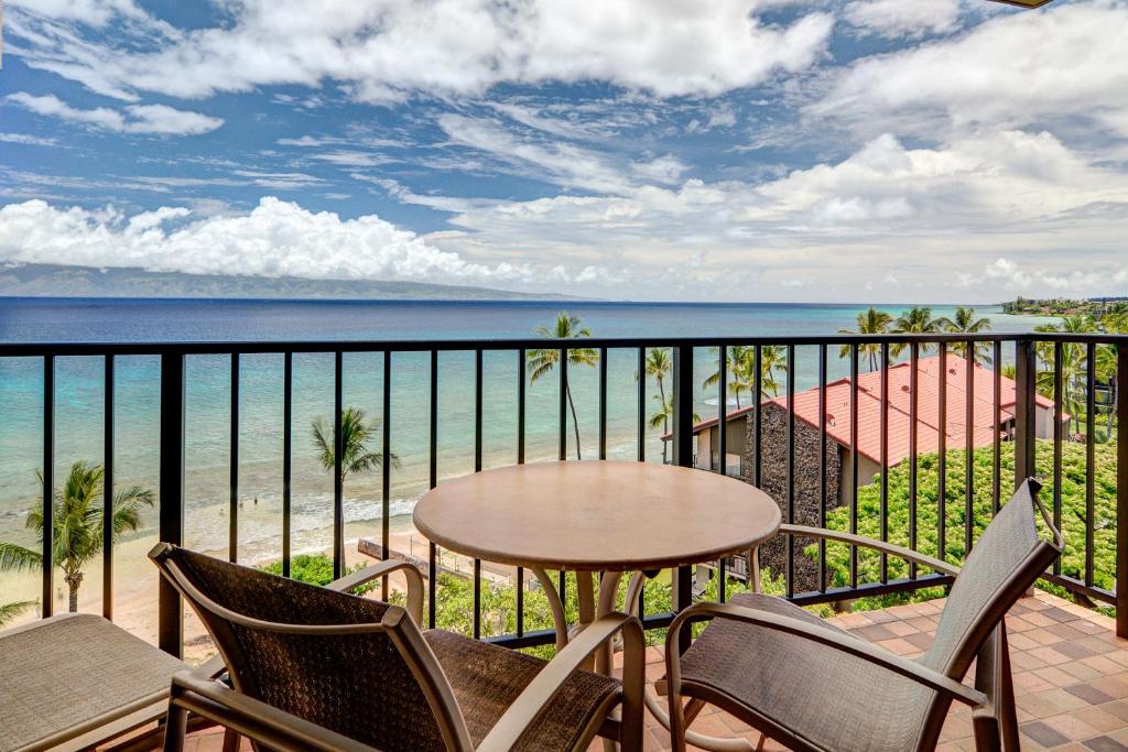 een balkon met een tafel en stoelen en de oceaan bij Kaanapali Shores 806 in Kaanapali