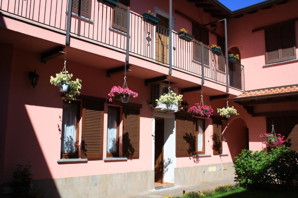 a pink building with potted plants on the windows at La Corte Albergo in Desio