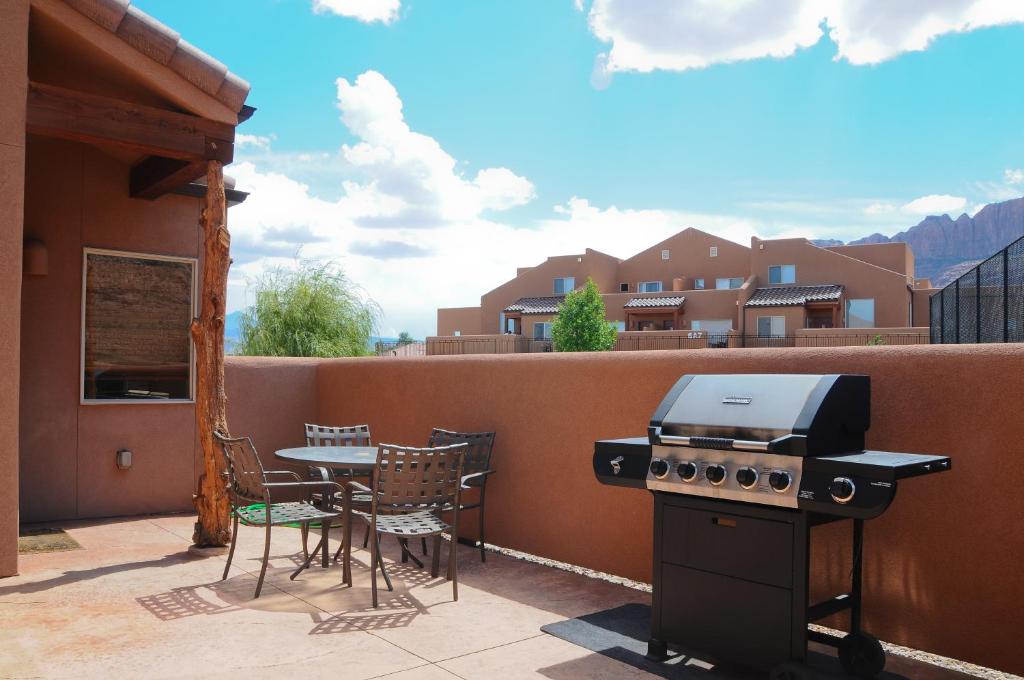 a grill on a patio with a table and chairs at Rim Vista 5A5 in Moab