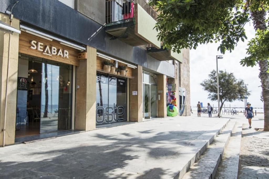 Sea Hostel Barcelona في برشلونة: شارع مقابل محل فيه ناس تمشي على الشارع