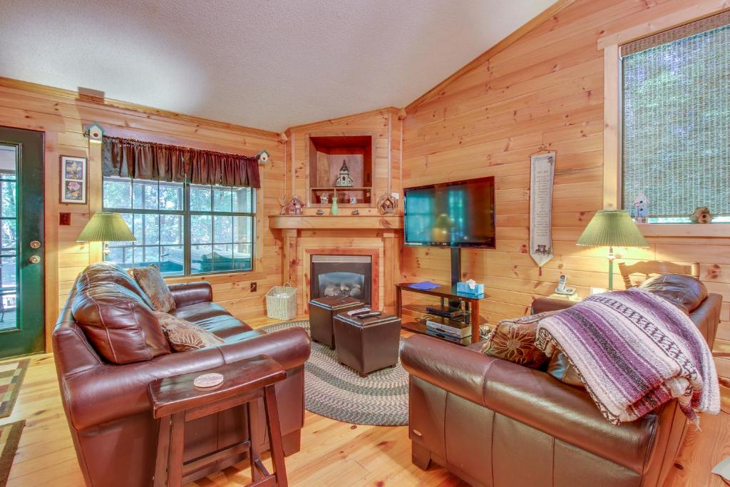 uma sala de estar com mobiliário de couro e uma lareira em Deer Hollow em Sautee Nacoochee