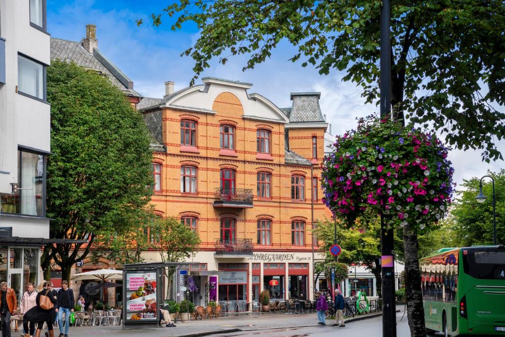 um grande edifício numa rua da cidade com um autocarro em The Villa by Frogner House em Stavanger