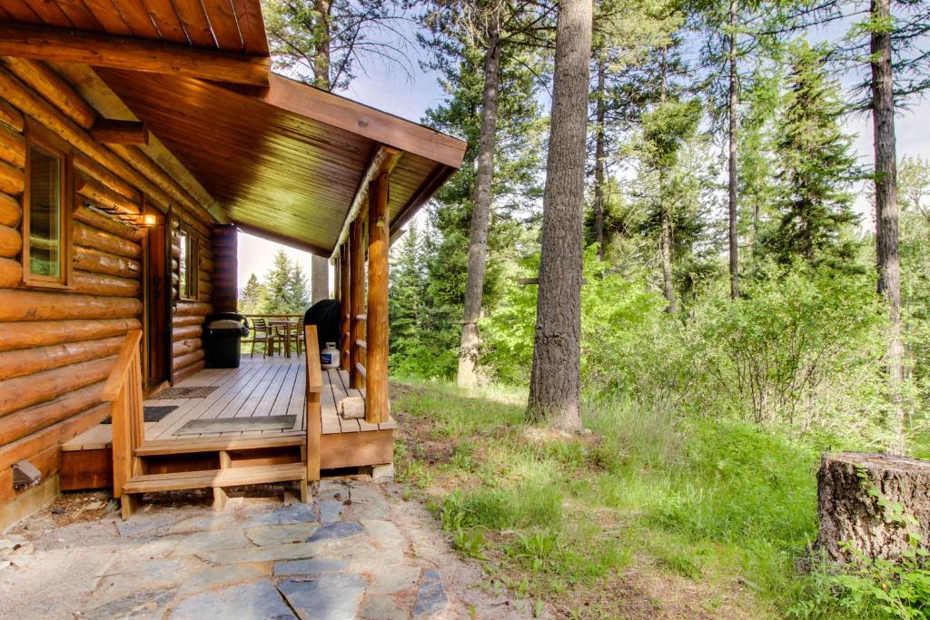 a cabin in the woods with a wooden porch at Blacktail Cabin in Somers