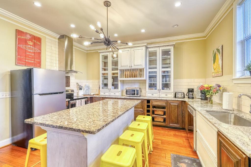 a kitchen with a large island with yellow stools at Savannah Lez Frederick: Premier in Savannah