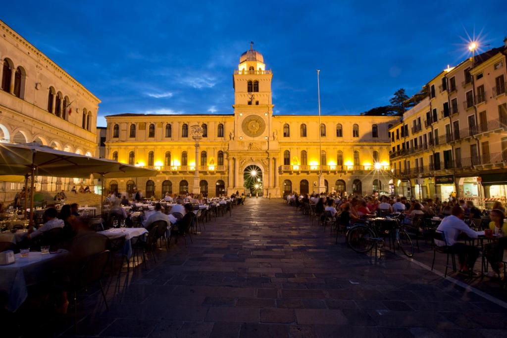 un grande edificio con persone sedute ai tavoli di fronte ad esso di Diamantino Town House a Padova