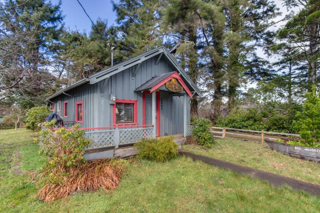 a small house with a red window in a yard at Sommers' Cabin in Gleneden Beach