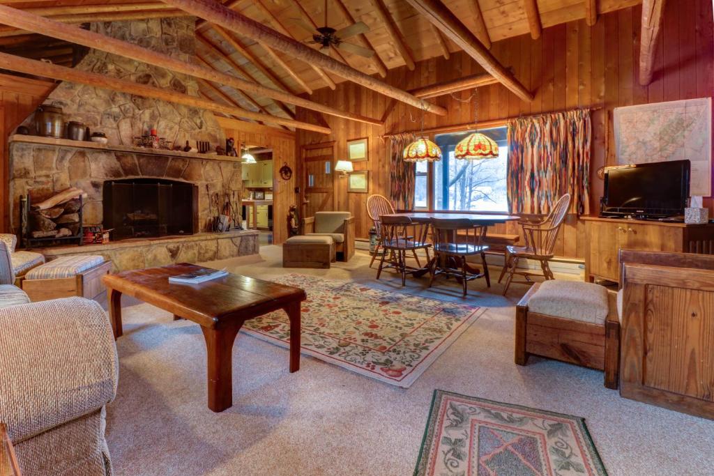 a large living room with a fireplace and a table at Pee Wee Acres in Thayerville