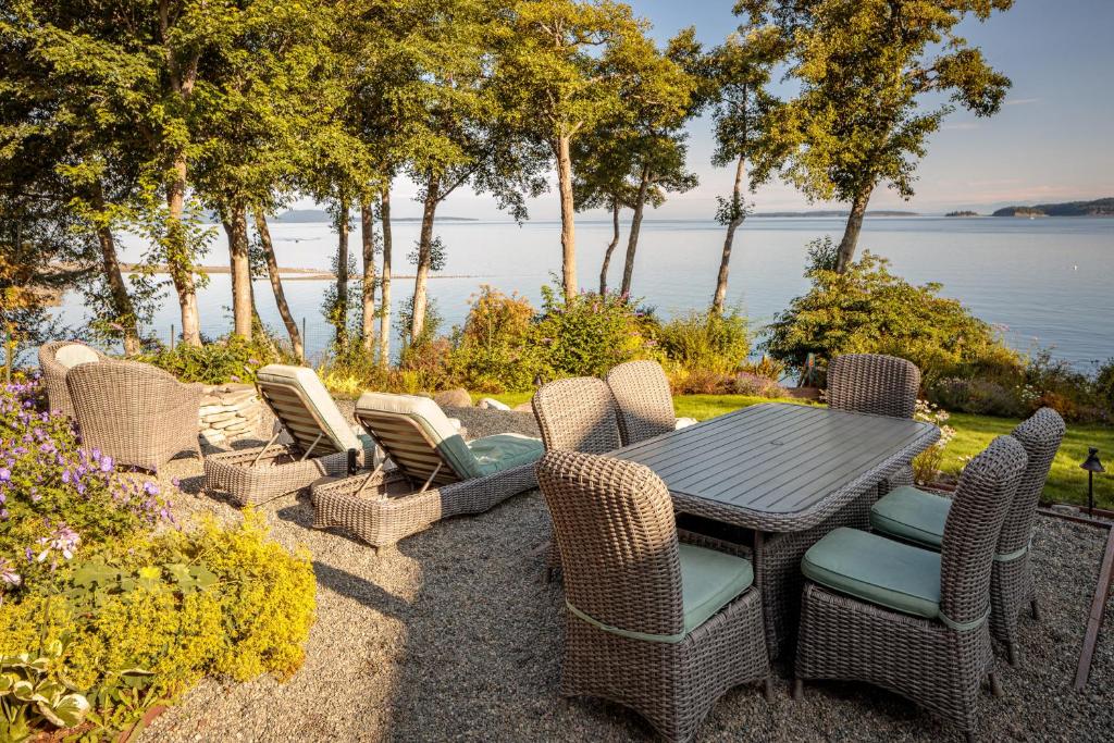 a table and chairs with a view of the water at Orcas Beach Cottage in Eastsound