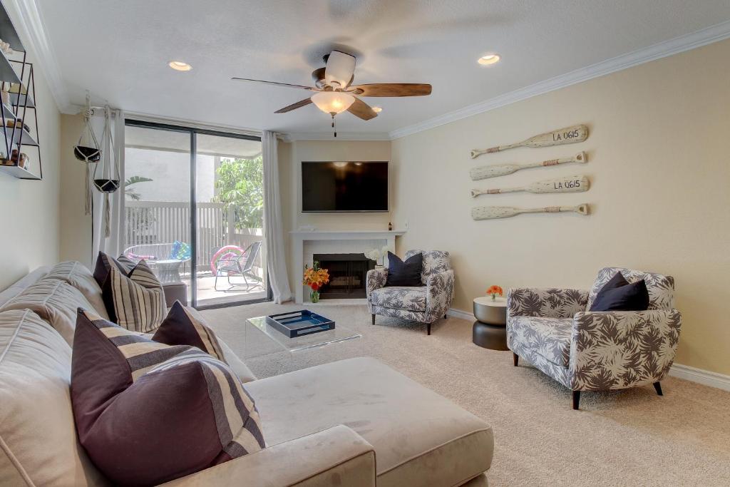 a living room with a couch and chairs and a ceiling fan at North Coast Village Retreat in Oceanside