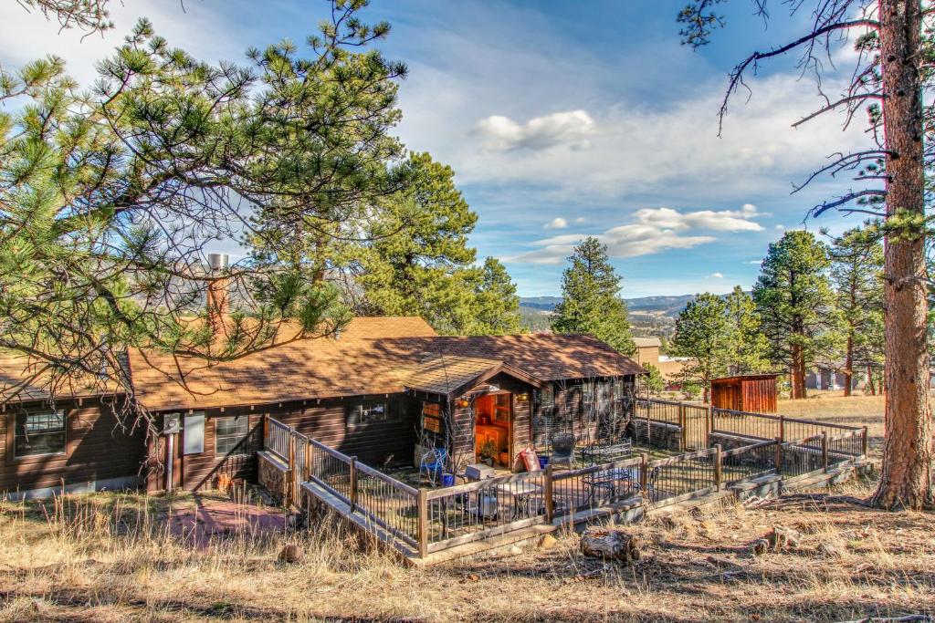 an old log cabin in a field with trees at Historic Wilderness Retreat in Estes Park