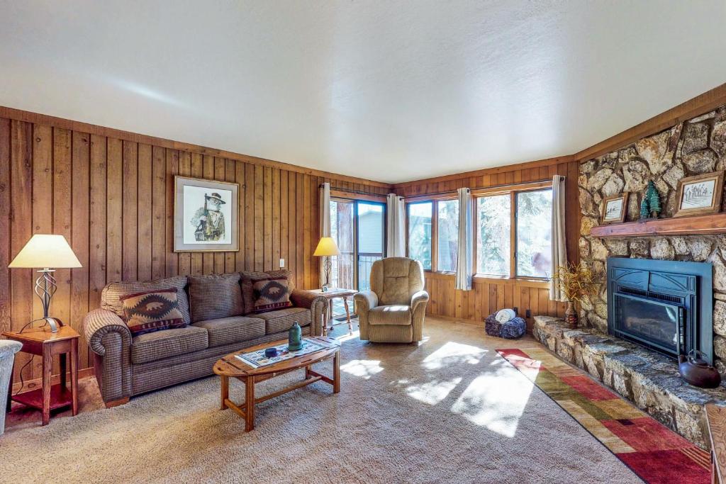 een woonkamer met een bank en een open haard bij Mountainback 47 in Mammoth Lakes