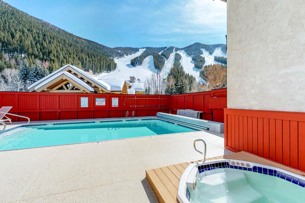 a swimming pool on top of a building with a mountain at Edelweiss Ski-In-N-Out & Unwind on Picabo St in Ketchum