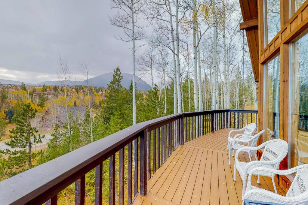 a porch with three white chairs on a wooden deck at Wildflowers Chalet in Silverthorne