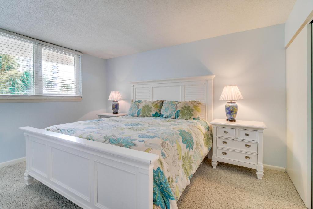 a white bedroom with a bed and two night stands at Dunes on the Bay in Pensacola Beach