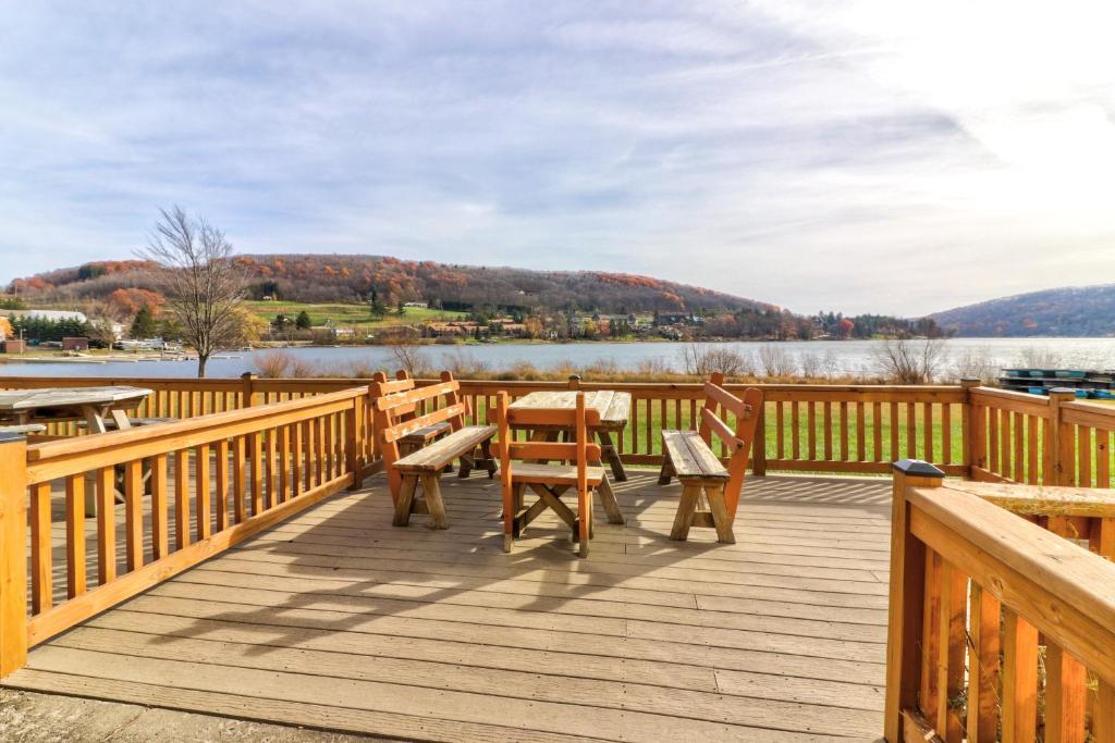 a wooden deck with a table and benches on a lake at Ski Harbor #15 in McHenry