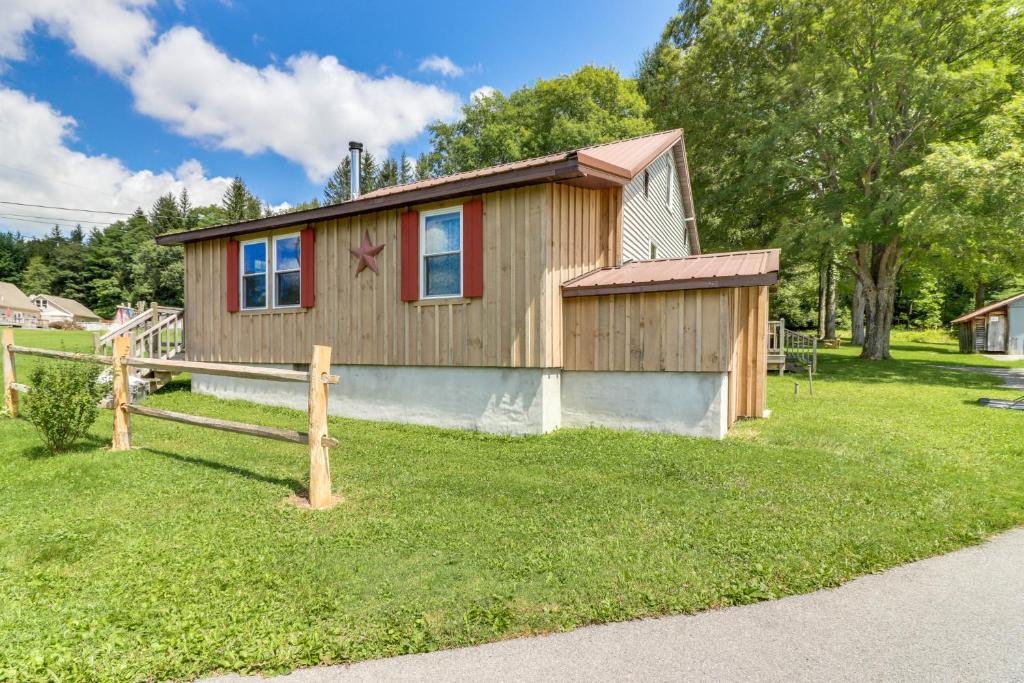 une petite maison en bois avec une clôture dans l'herbe dans l'établissement Still Meadows, à McComas Beach