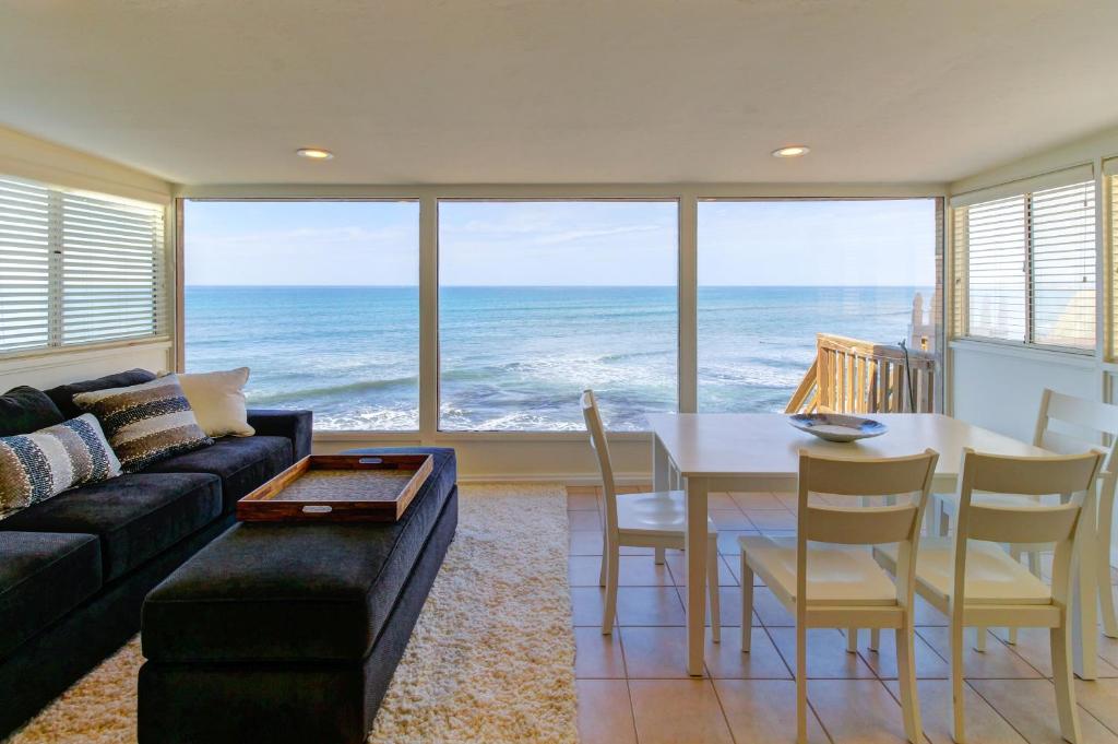 uma sala de estar com uma mesa e vista para o oceano em Seafoam Sunset em San Diego