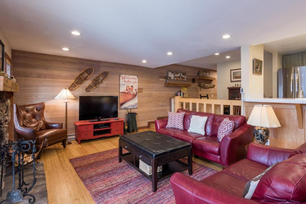 a living room with red leather furniture and a flat screen tv at Snowcreek Delight in Sun Valley