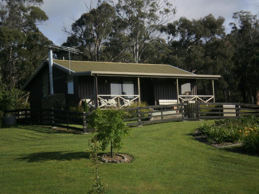 una casa negra con una valla y un patio en Duffy's Country Accommodation, en Westerway