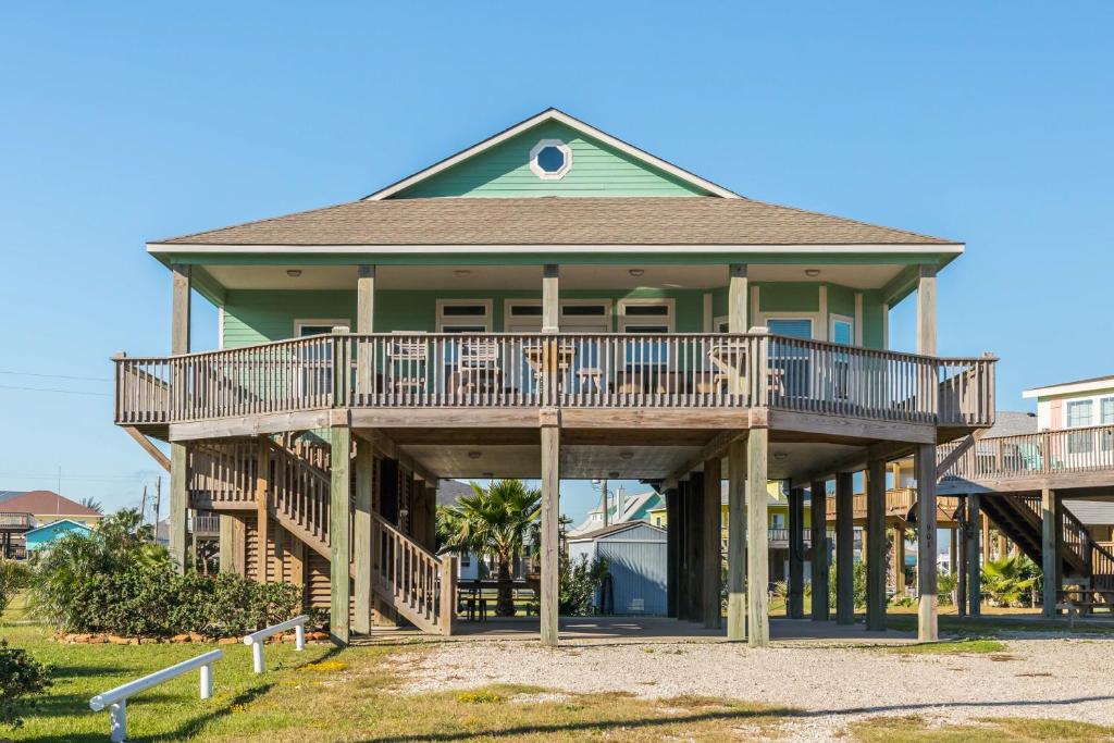 a house with a large deck on a beach at Beachslapped in Bolivar Peninsula