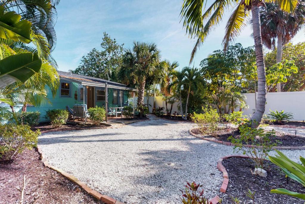 una casa con palme e un vialetto di ghiaia di Sea Palm Cottage a Ilexhurst