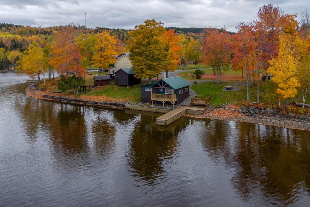 a house on a dock next to a body of water at Rockwood Cabin on Moosehead Lake in Rockwood