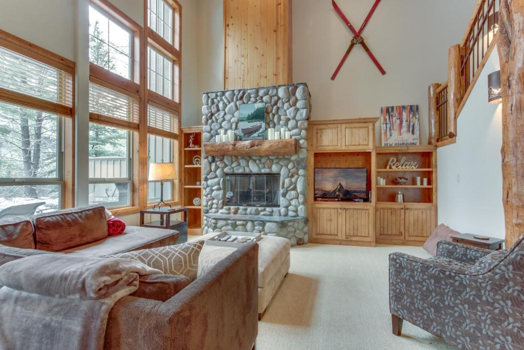 een woonkamer met een bank en een stenen open haard bij 18 Aquila Lodge in Sunriver