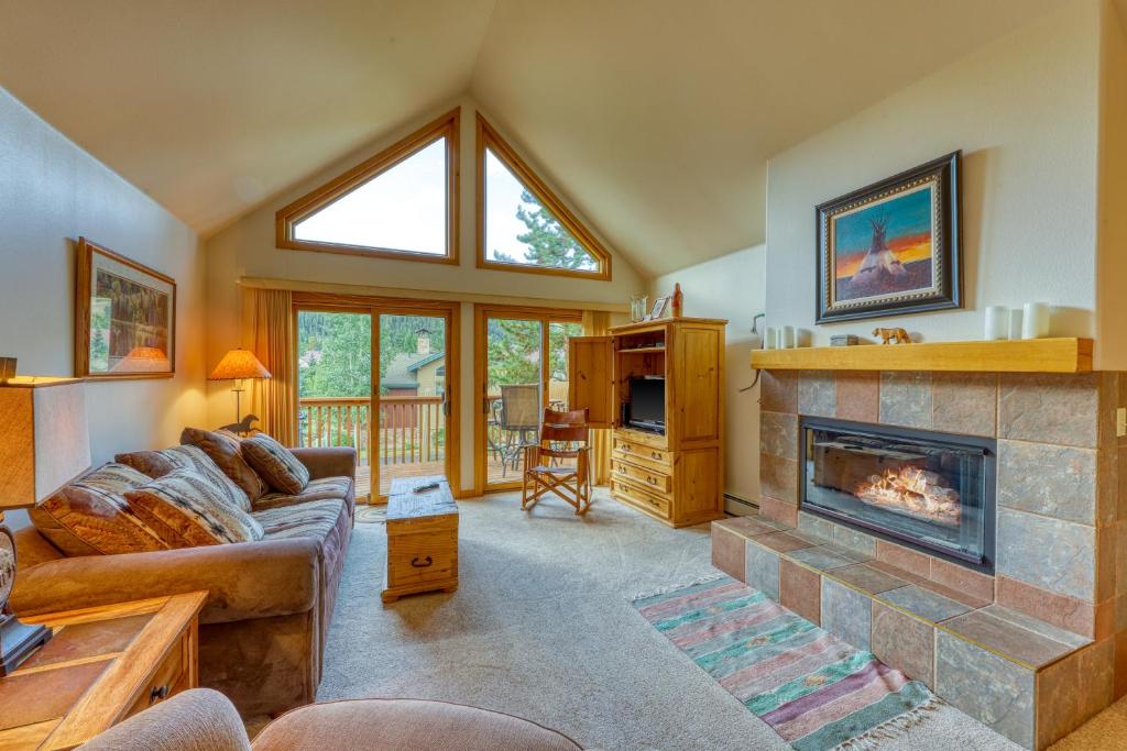 a living room with a fireplace and a couch at Snake River Village 05 in Keystone