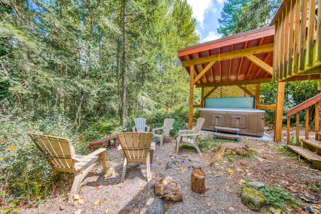 une terrasse avec des chaises et un barbecue dans les bois dans l'établissement Riverside Retreat, à Mount Hood Village