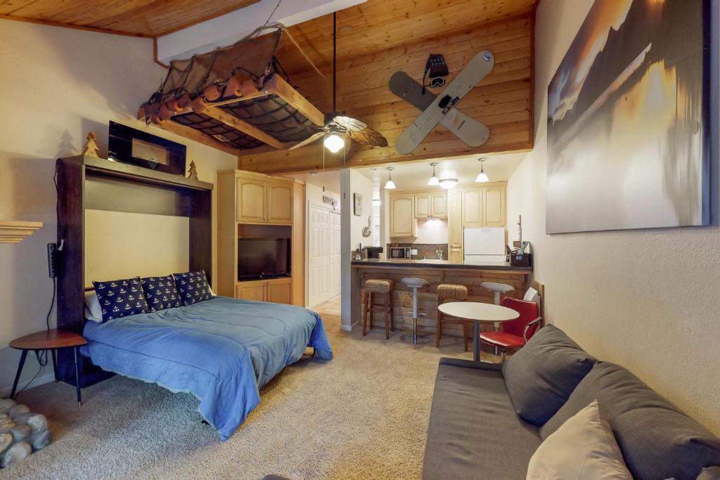 a living room with a bed and a kitchen at The Lake House in Shaver Lake