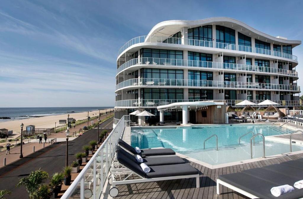 a hotel with a swimming pool next to a beach at Wave Resort in Long Branch