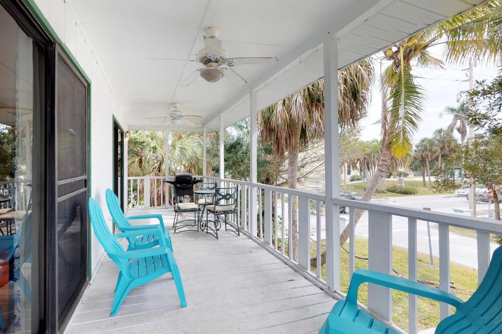 a porch with blue chairs and a grill at Sandy's Getaway in Anna Maria