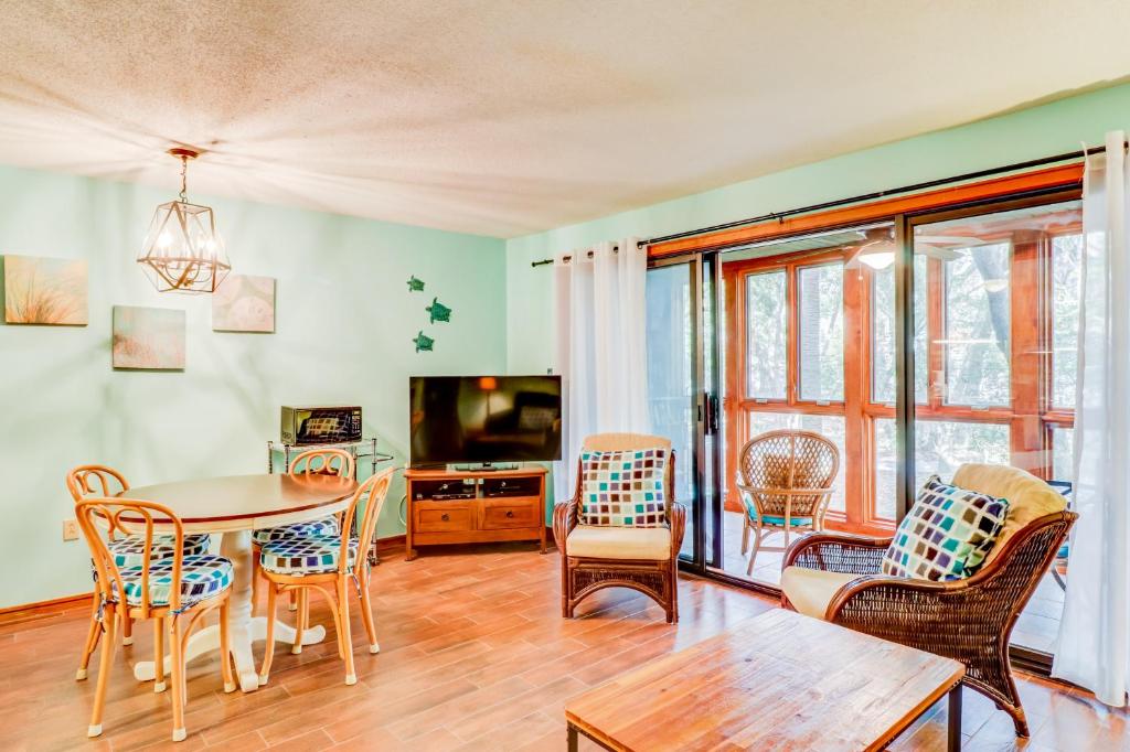 sala de estar con mesa, sillas y TV en 3542 Seascape Villa, en Kiawah Island