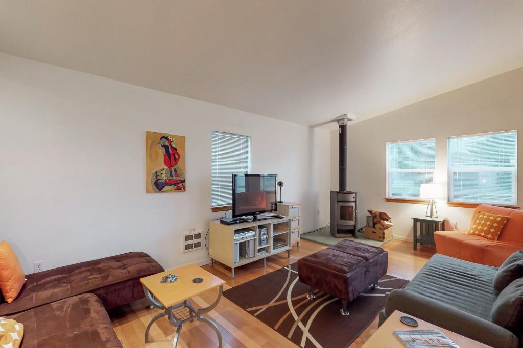 a living room with a couch and a tv at Mermaid Beach House in Bandon