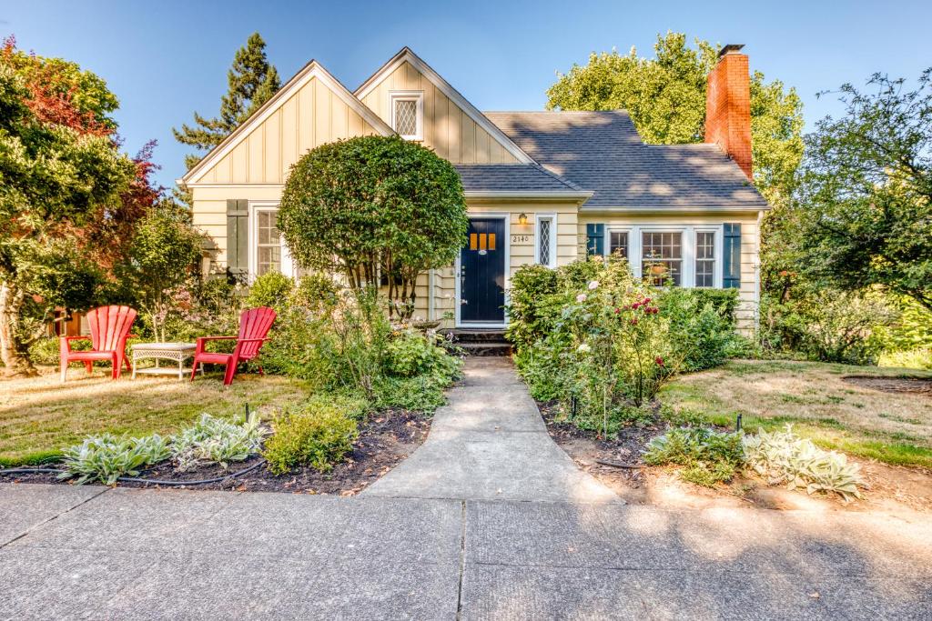 a house with two red chairs in the front yard at Washburne Park Retreat in Eugene